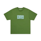 Urban Cult x CPFM T-Shirt Verde Oliva in cotone con grafica "Dollar" e faccina sorridente.