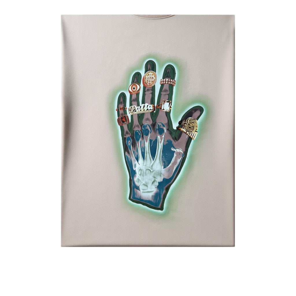 Urban Cult T-shirt Patta 'Healing Hands' rosa pastello in cotone pesante con grafica di una mano scheletrica con anelli dorati e aura verde neon.