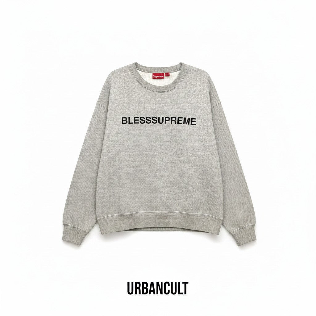 Felpa Urban Cult Supreme Bless Crewneck grigio melange in cotone pesante con grafica ricamata sul petto.