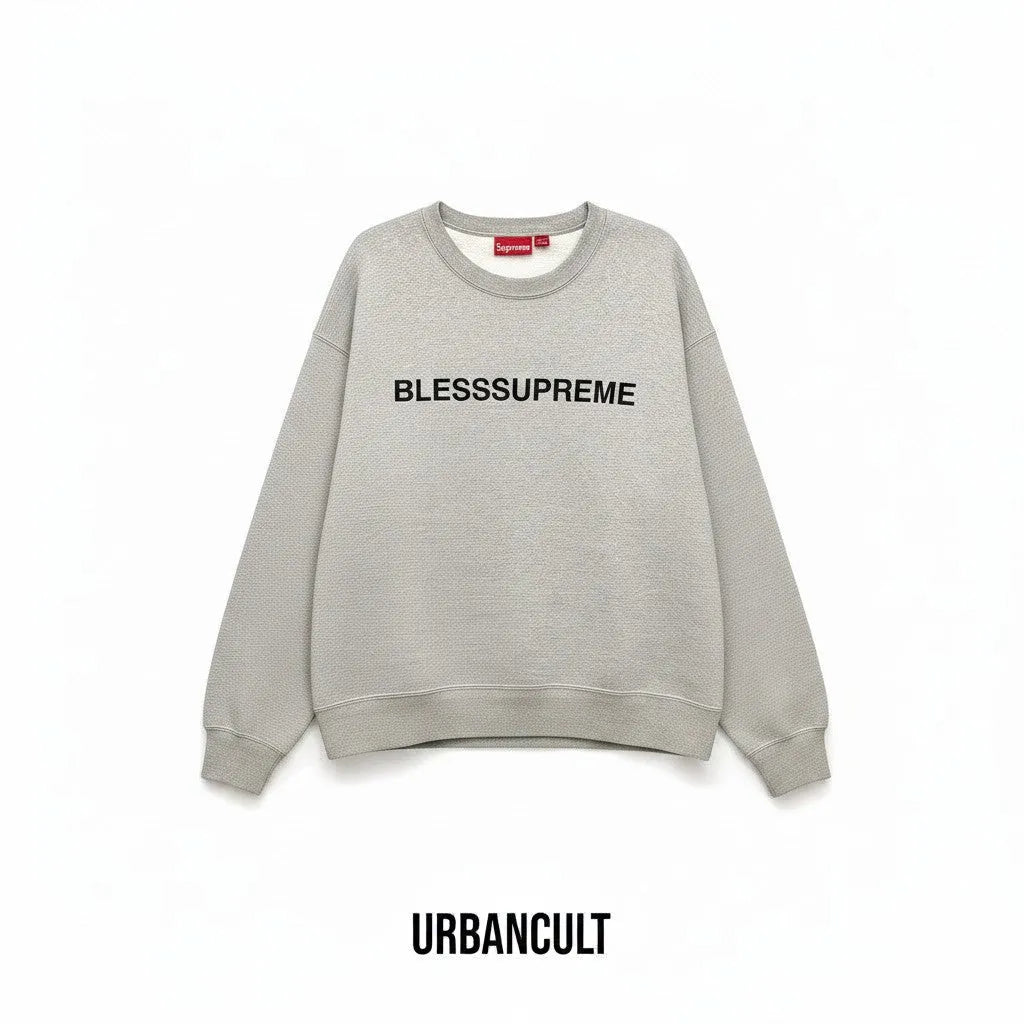 Felpa Urban Cult Supreme Bless Crewneck grigio melange in cotone pesante con grafica ricamata sul petto.
