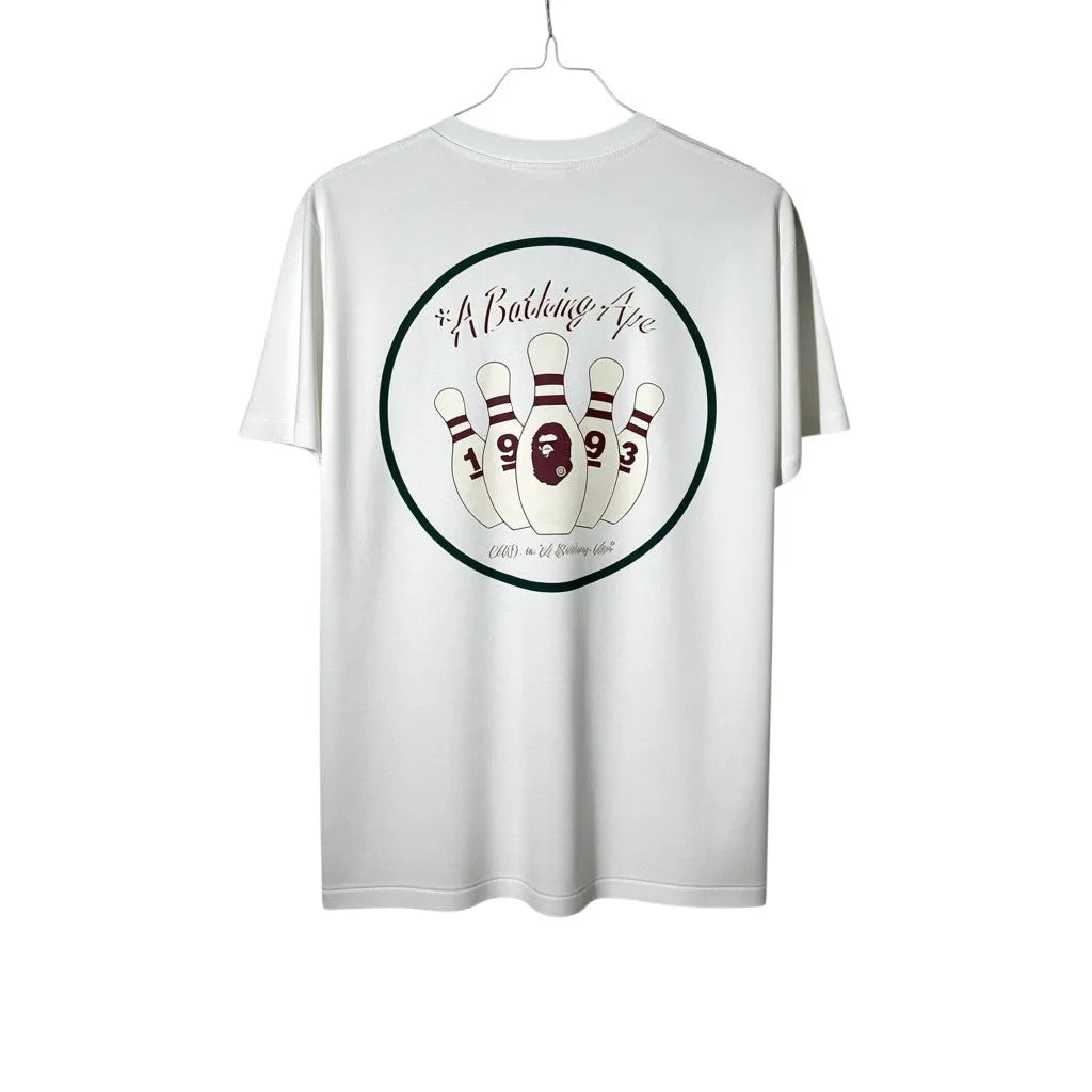 Urban Cult T-Shirt BAPE x End Bowling Tee Bianca in cotone con stampa grafica di birilli da bowling e logo Ape Head.