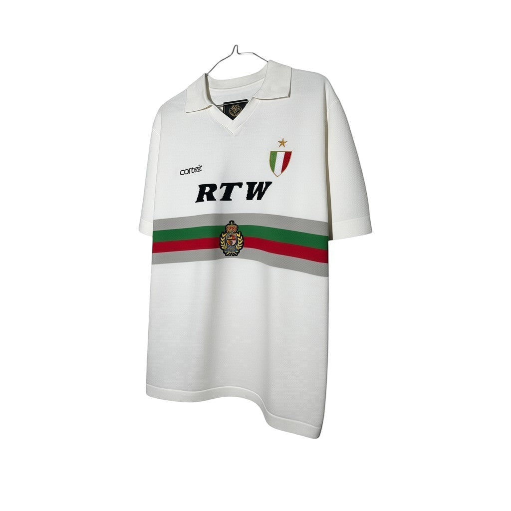 Urban Cult maglia knit bianca Corteiz Serie A con dettagli a righe rosse, verdi e grigie e stemma sul petto.