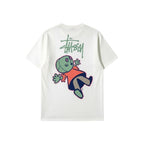 Urban Cult white pigment-dyed cotton t-shirt with Stüssy logo and playful 'Dollie' graphic on back.